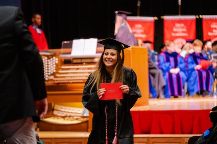 A Radford University student smiles after walking across the stage at Winter Commencement.
