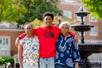 student with family in front of fountain