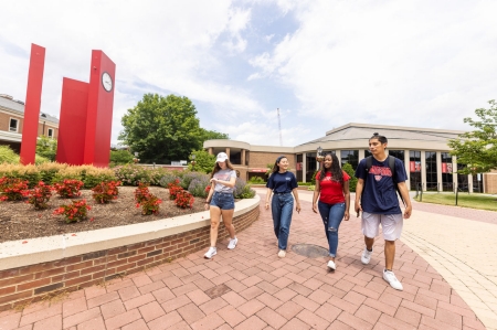 students walking on main campus near red clocks