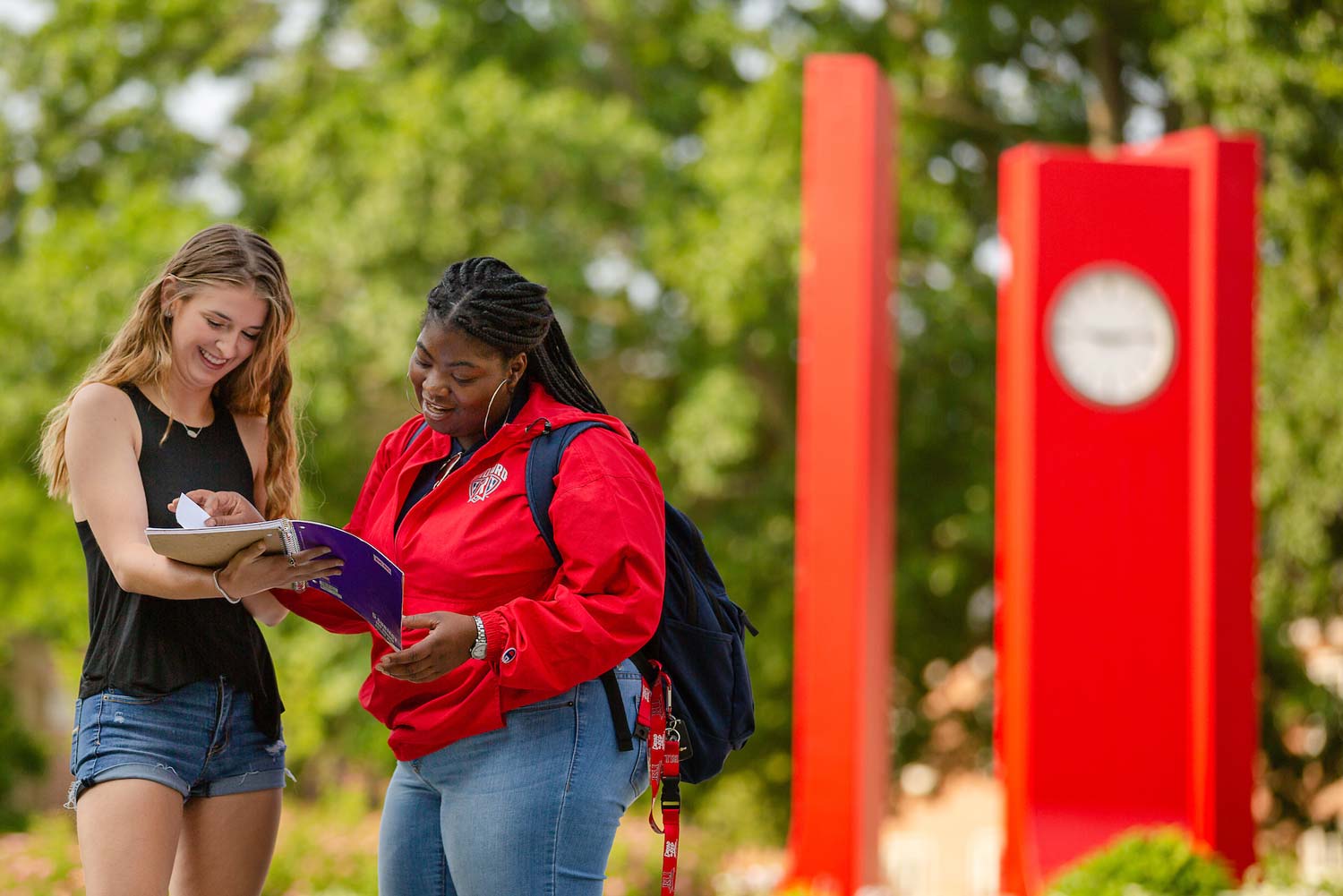 students in front of red Heth clocks