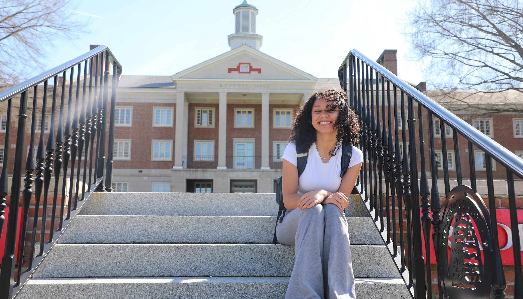 young woman student on steps of a buidling on Radford University campus