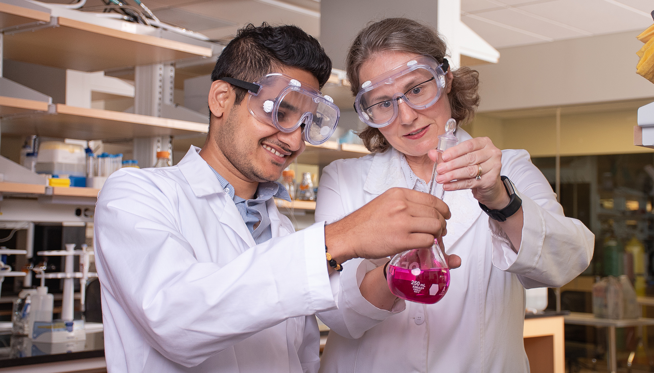 student and professor with beaker