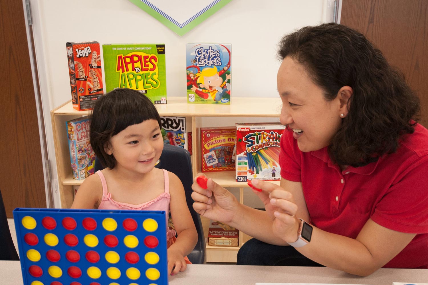 female teacher with a small child in a classroom setting