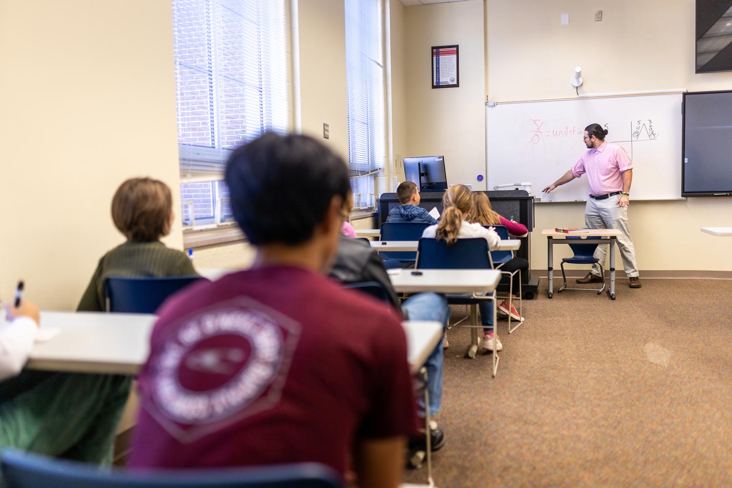 male student teacher in front of classroom