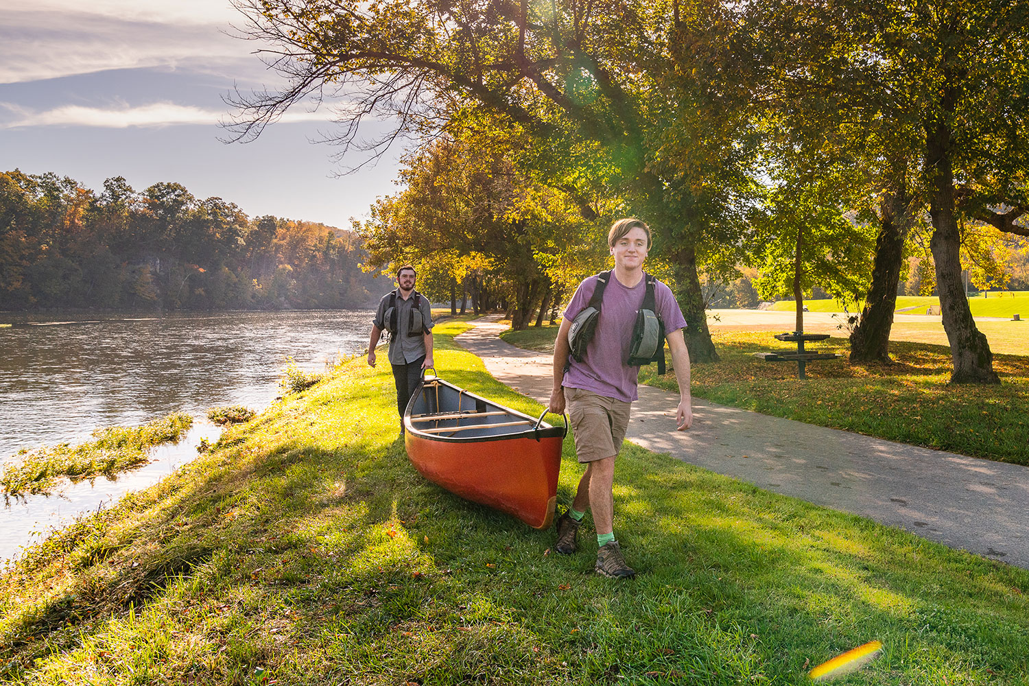 Students interested in outdoors carrying a canoe to the river.