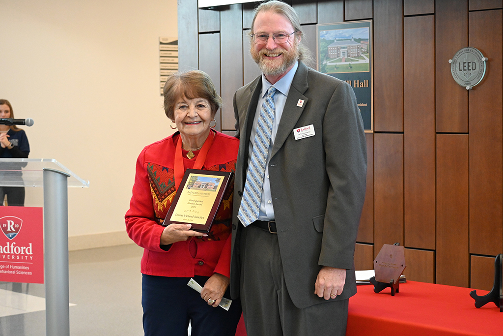 Dr. Emma Violand-Sánchez with Dean of the College of Humanities and Behavioral Sciences, Jeff Aspelmeier, receiving the 2025 Outstanding Alumni Award.