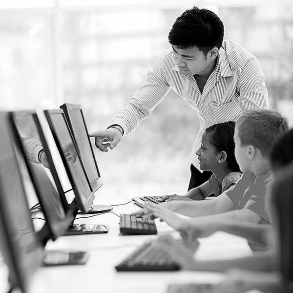 teacher helping his stuents in a computer lab