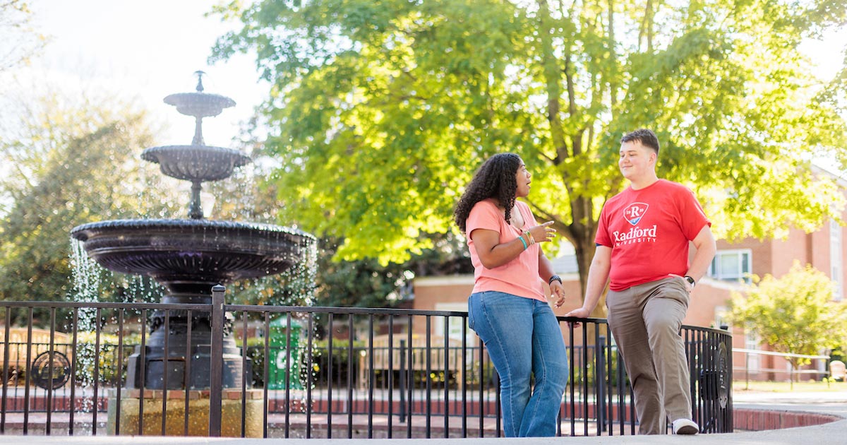 students standing in front of the fountain on main campus