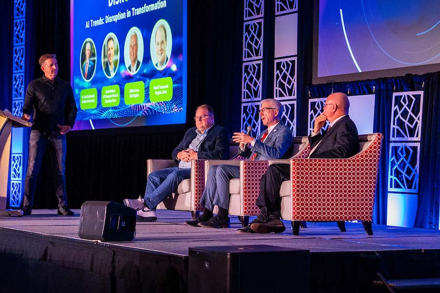 Radford's president participates in an onstage roundtable discussion with two other technology experts. 