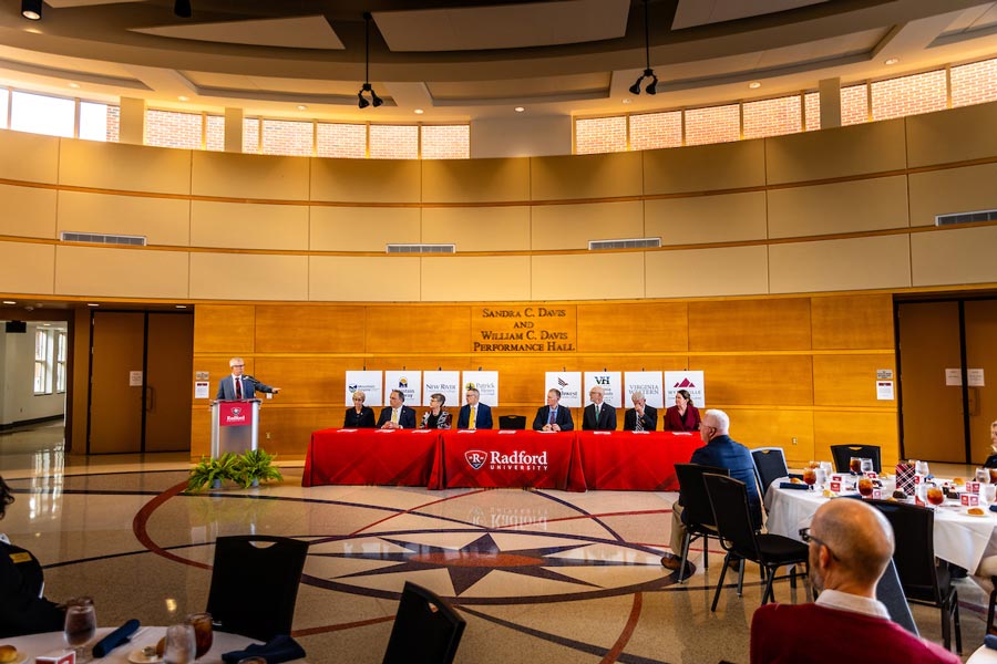 Radford University's president and the heads of eight local community colleges participate in a signing ceremony in a large hall.