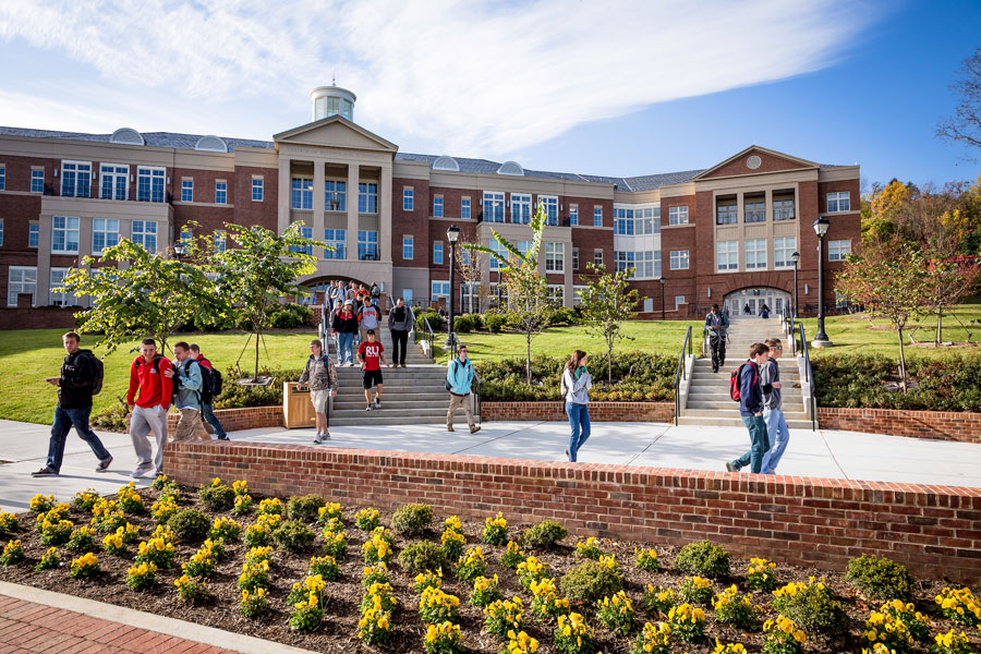 students walk outside Kyle Hall on a sunny day. 