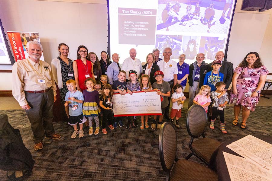 A group of children, instructors and volunteers gather at an event in Kyle Hall