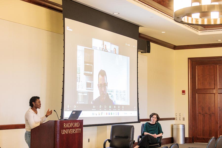 A woman at a lecture engages in a World Food Day discussion with a man on Zoom.