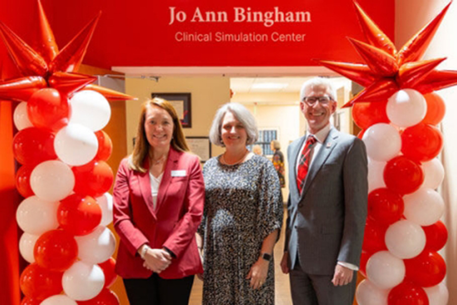 Christina Keller, D.N.P., Wendy Downey, D.N.P., and President Bret Danilowicz in front of the Jo Ann Bingham Clinical Simulation Center sign.