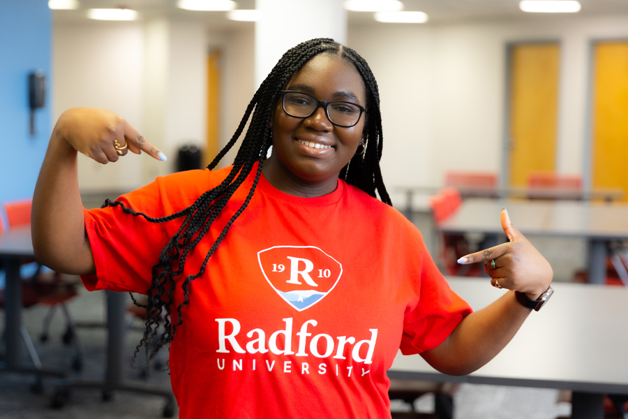 Radford University student Leslie Witherspoon smiling at the camera wearing a shirt that says Radford University