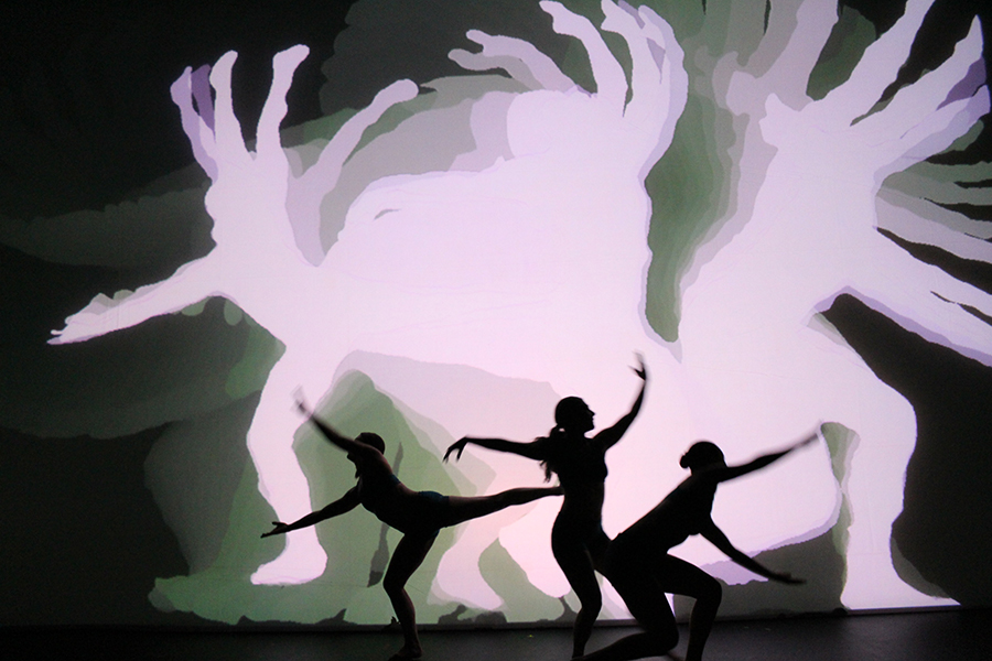 Three shadow dancers with projection behind them.