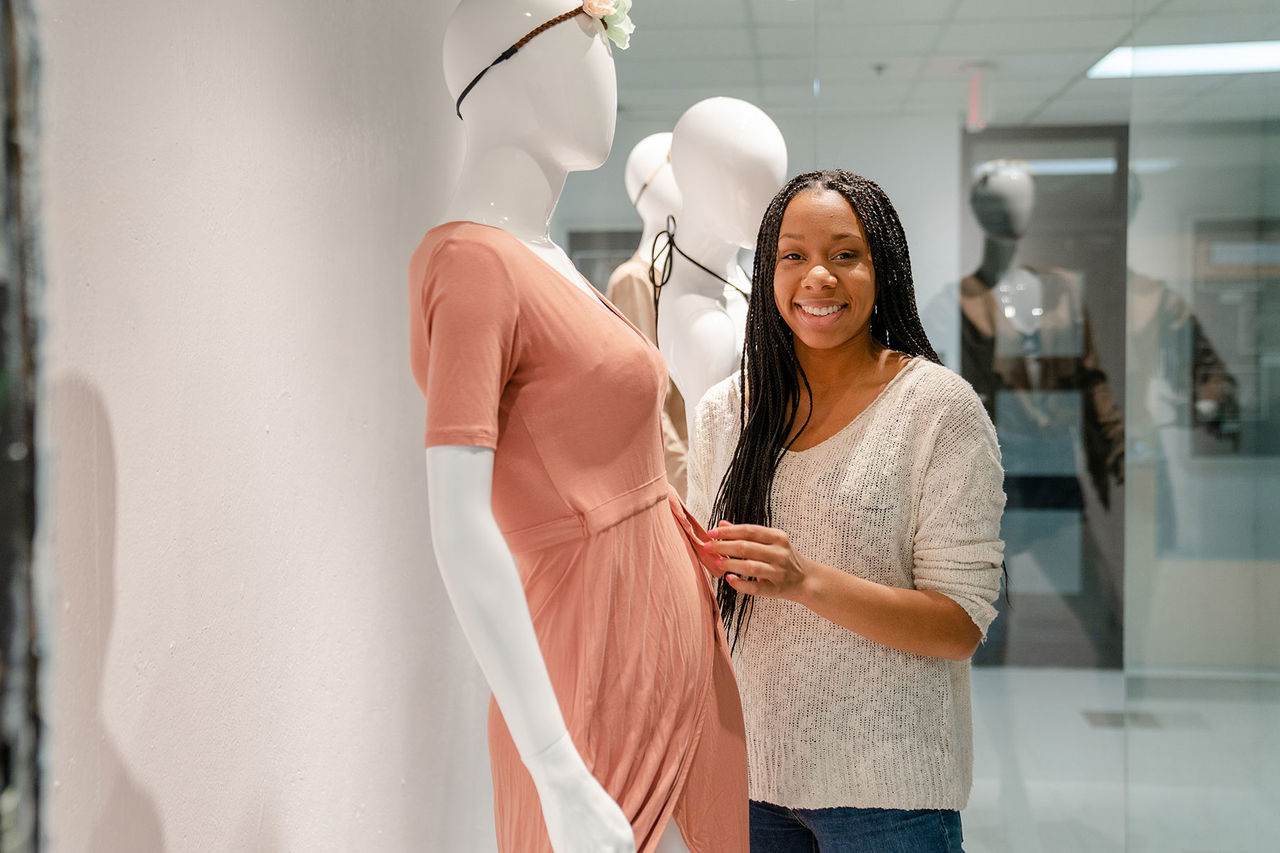 student dressing a mannequin