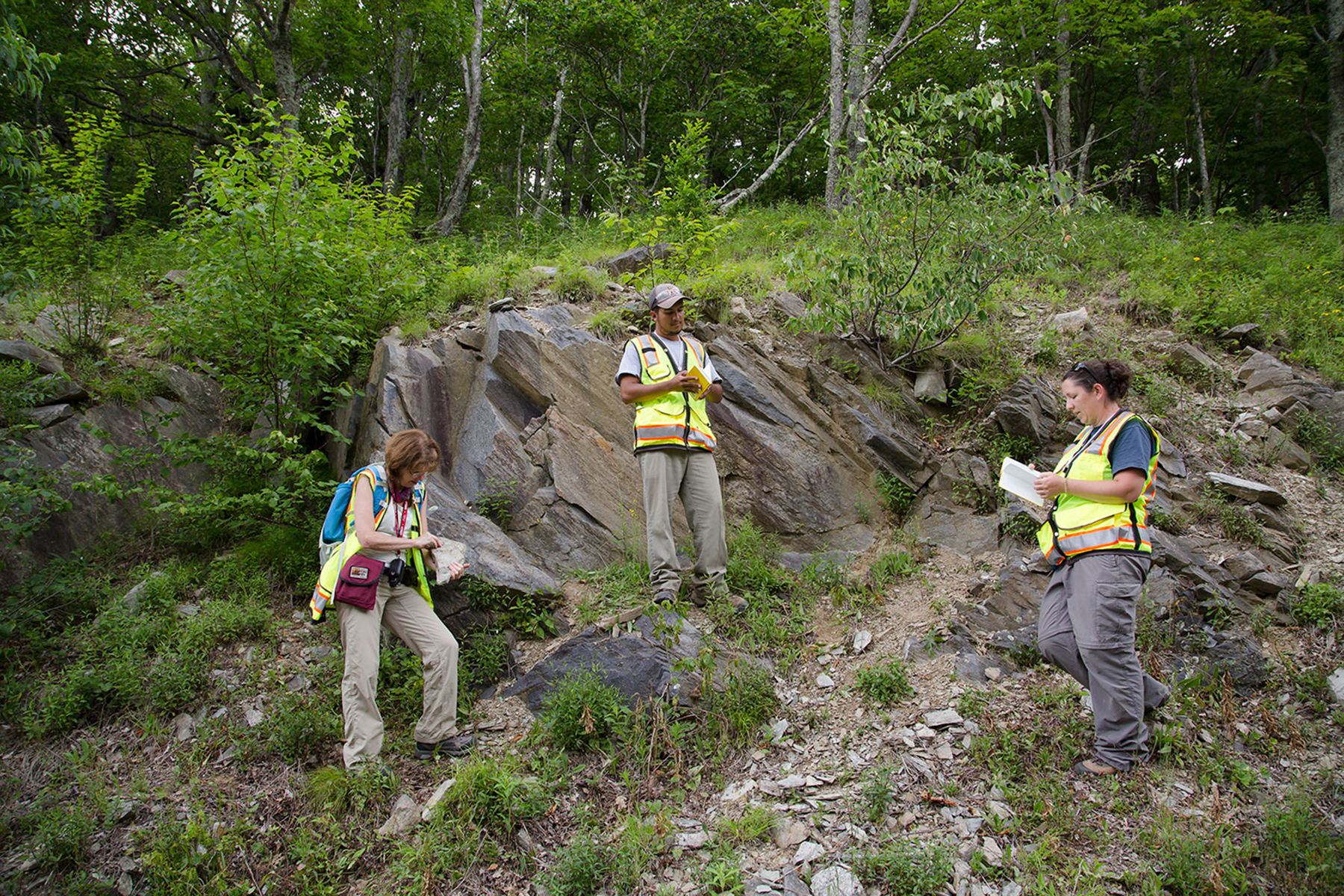 A group of students on a rocky hillside taking notes