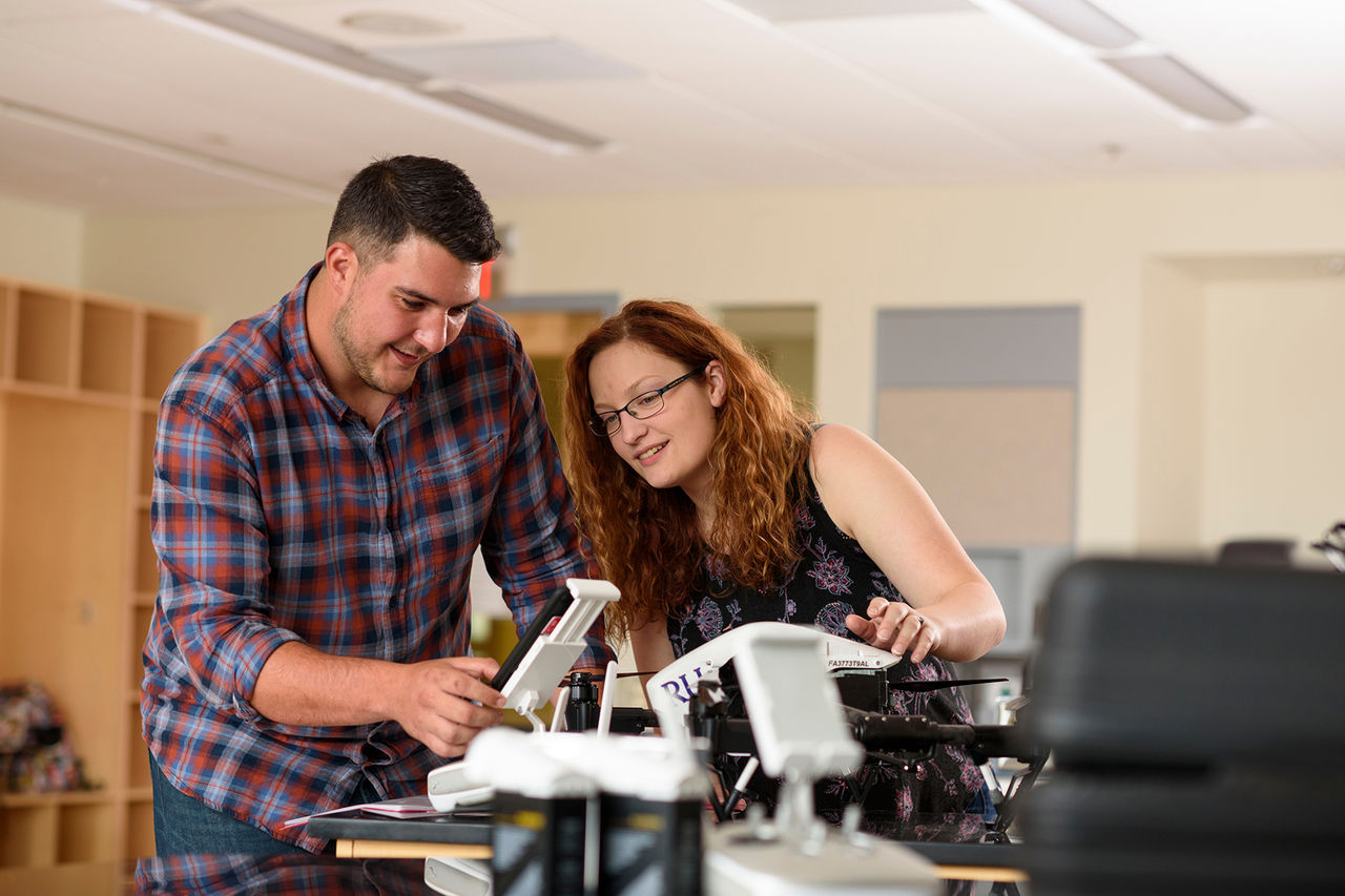 Two students together in a lab looking at a geology device