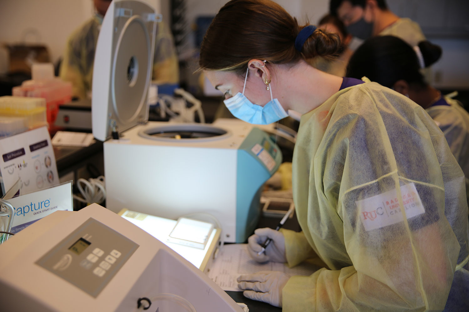 student with a mask on looking at some medical equipment