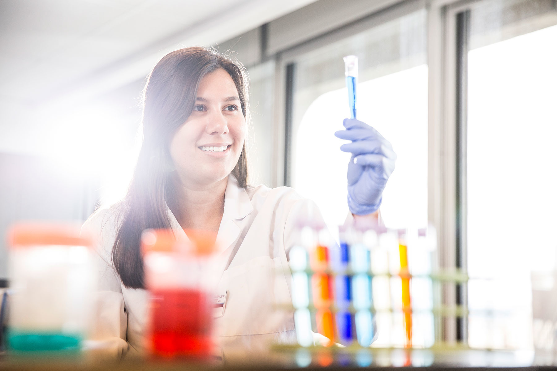 student holding up a blue test tube