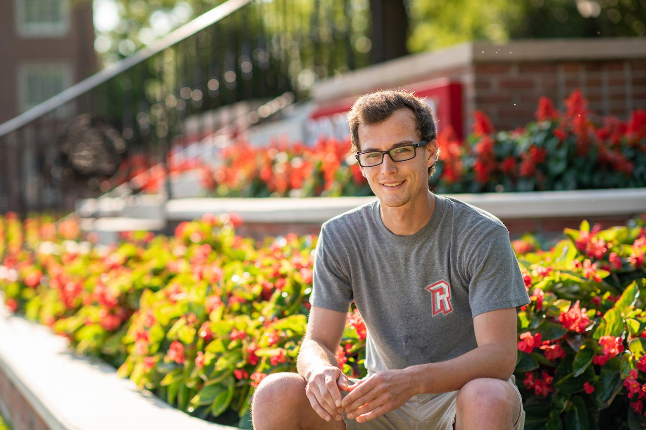 student sitting on the edge of a garden