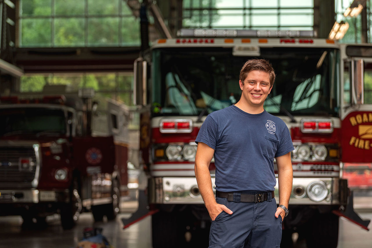 student smiling in front of a firetruck