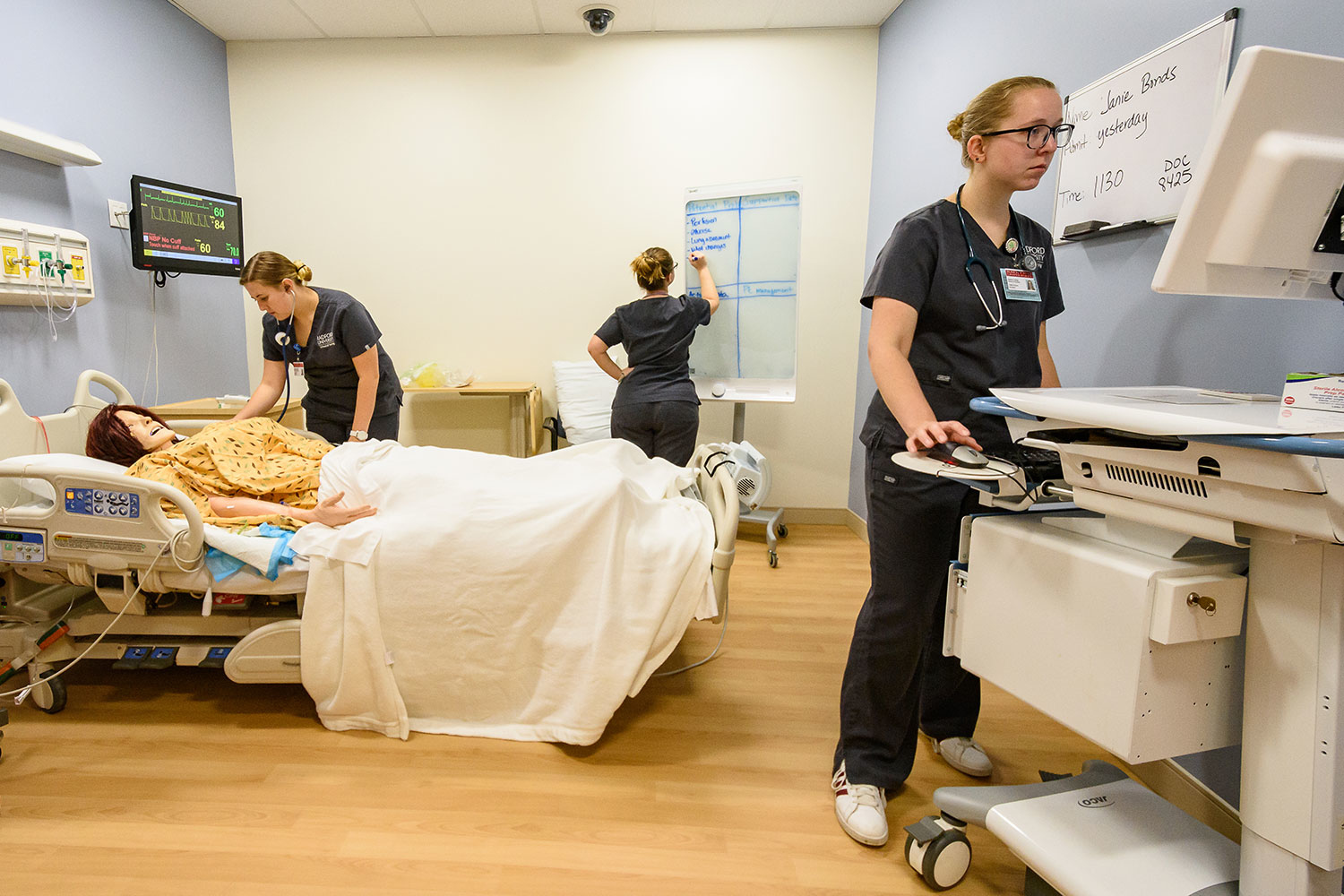 three nursing students spread across a hospital room