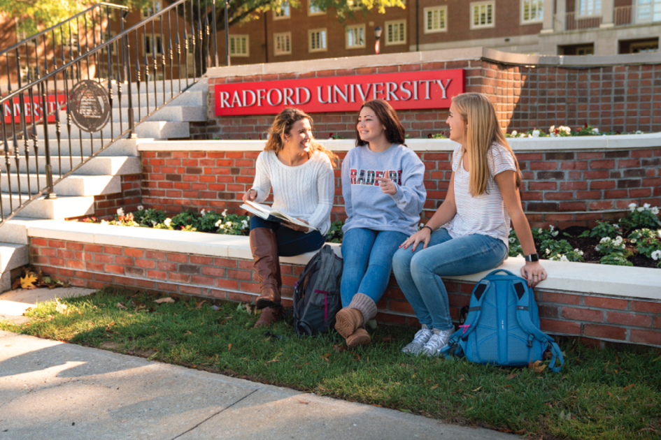 students sitting on sign
