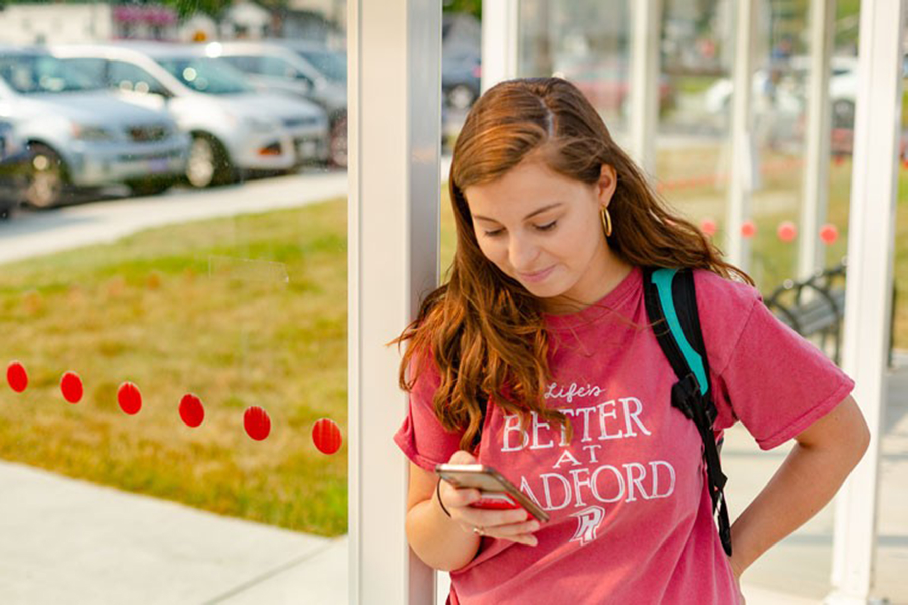 Student looking at her cell phone on campus.
