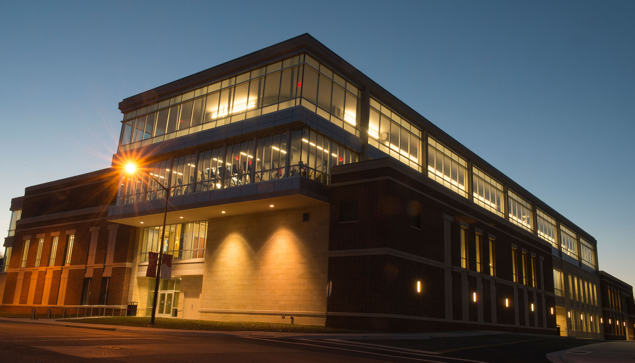 photo of the Student Recreation and Wellness Center from the street at night.